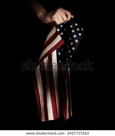 Memorial Day background. Human's hand holding grunge flag of United States of America
