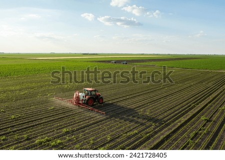 Tractor spraying pesticides at soy bean fields
