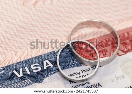 Wedding rings on passport with us visa as concept of marriage of convenience Royalty-Free Stock Photo #2421743387