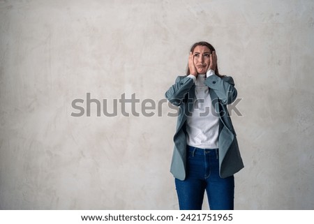 Devastated young business woman about to cry, can't handle her problems, modern life pressure, posing in a studio against a gray background with copy space.