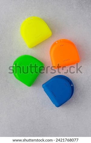 Multi-colored containers for dental plates. Box for orthodontic mouthguard Royalty-Free Stock Photo #2421768077