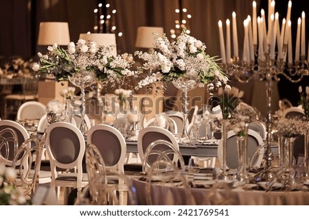 Banquet dinner tables grey white chairs and white flower bouquet stock photo