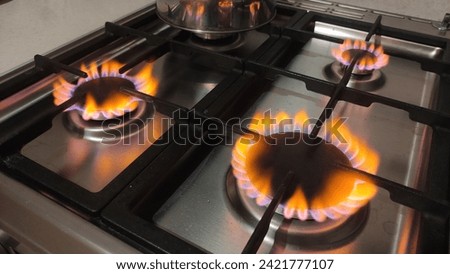 Natural gas burns orange yellow when there is a lack of oxygen. Danger of carbon monoxide poisoning in the kitchen gas stove Royalty-Free Stock Photo #2421777107