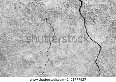 The wall of an old building with winding, deep cracks. Copy space. Black and white photo. Selective focus. Royalty-Free Stock Photo #2421779627