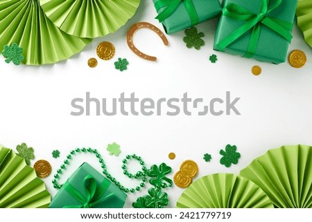 Charm-infused presents: Unique gift ideas for St. Paddy's Day. Top view shot of present boxes, folding fans, horseshoe, trefoils, coins, beads on white background with advert area