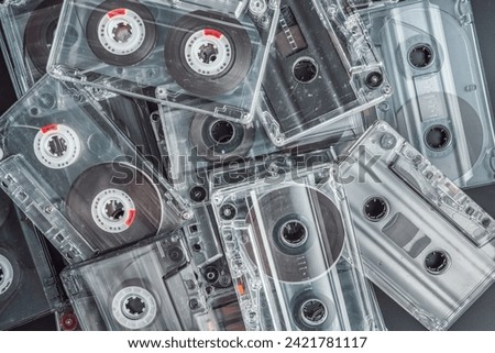 A stack of audio tape cassettes on black background. Retro vintage music concept. Royalty-Free Stock Photo #2421781117