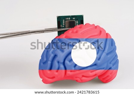 On a white background, a model of the brain with a picture of a flag - Laos, a microcircuit, a processor, is implanted into it. Close-up