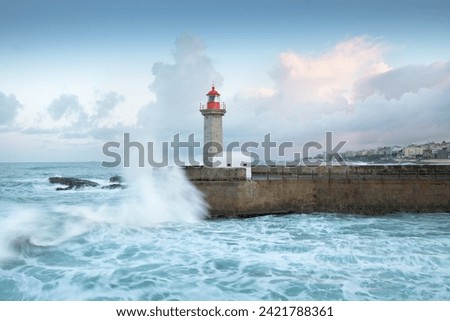 Beautiful sunset on the old pier and The Felgueiras Lighthouse at the mouth of the river Douro, Porto, Portugal
Big breaking sea wave splash at sunset.