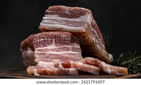 Two large pieces of bacon sliced in close-up. The background picture.