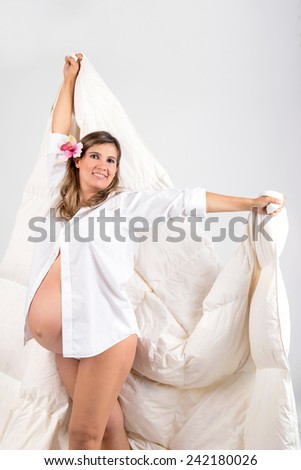 Beautiful pregnant woman posing isolated in white