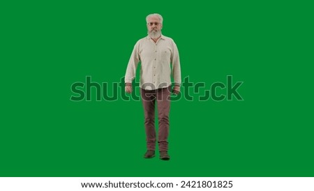 Portrait of aged bearded man on chroma key green screen. Full shot senior man walking and looking at the camera, positive expression.