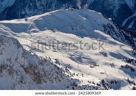 Ski resort in the Dolomites. Mountain recreation place. Ski slopes in the Dolomites on a clear sunny day. Alpine skiing sport and recreation. Snowboard track Royalty-Free Stock Photo #2421809369