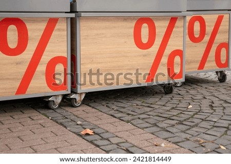 Sale sign outside store on the street. Wood background.