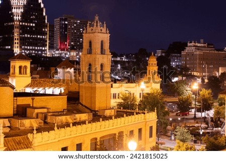 Night time view of historic church towers and downtown skyline of Kansas City, Missouri, USA.