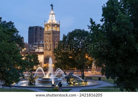 Twilight view of a historic fountain and skyline of Kansas City, Missouri, USA.