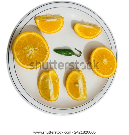 A plate of oranges with a  green chili in the center, showcasing a striking combination of colors and flavors.