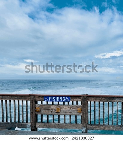 Handicap fishing zone with blue fishing sign on a wooden rallying with blue ocean and horizon. Fishing zone on sea ocean.