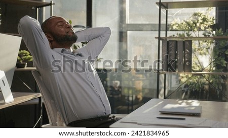 Satisfied businessman African American mature middle-aged 45s man finish computer project close laptop work day off lean back on chair put hands behind head take break relaxing in sunshine warm office Royalty-Free Stock Photo #2421834965