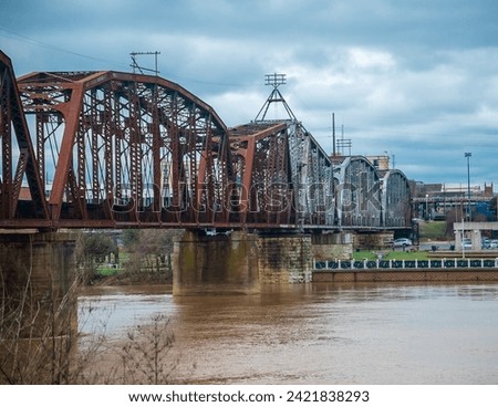 Train bridge extending over a river leading into the city Royalty-Free Stock Photo #2421838293