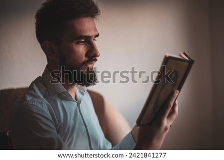 Religious arab muslim man reading holy quran at home. High quality photo