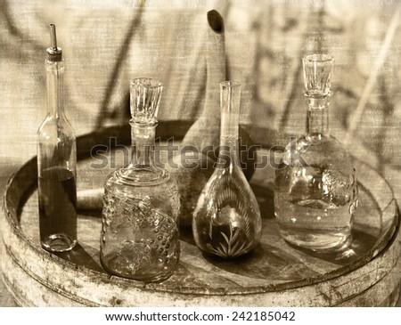 Vintage Glass utensils for wine, cognac and chacha tasting on the oak barrel in a Caucasian wine cellar. Styli of picture in the old newspaper. Caucasus, Georgia 