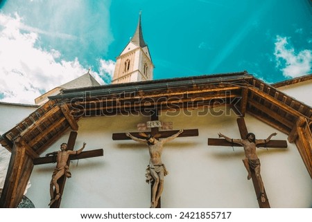 Jesus Christ and martyrs crucifixion on wooden crosses in the Church of St. Leonard.Church of St. Leonard in Lungau, Austria. August 2023. Catholic Church architecture outside. 