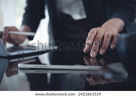 Businesswoman using digital tablet and laptop computer at office. Business woman working, touching on tablet, using laptop computer, searching business data, surfing internet on office table, close up