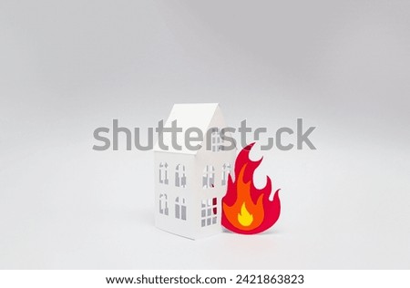 House and flame made of cardboard on gray background. Fire concept. Selective focus, copy space