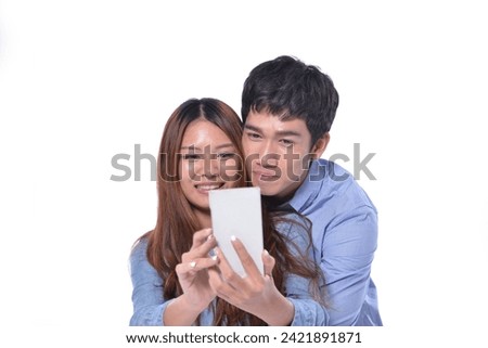 happy young couple in casual wear blue shirt using cellphone on white background
