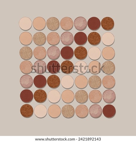 Square Pattern of color gradient swatches of eye shadows on neutral colored background. Beige brown skintone natural color eyeshadow powder, shiny an matte, minimal aesthetic photo, top view, flat lay