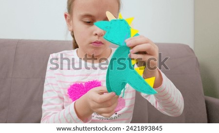 A girl is sewing a toy. Classes with children. Children's hobbies. High quality photo