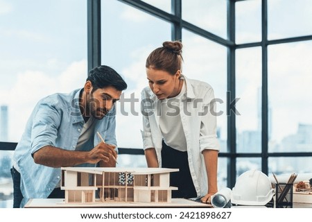 Smart caucasian architect engineer team working together to measure house model. Group of professional interior designer brainstorming and sharing ideas about design building construction. Tracery. Royalty-Free Stock Photo #2421898627