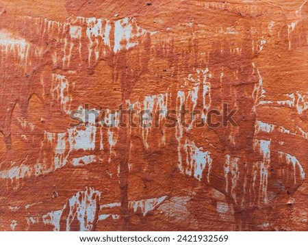 Cement walls are painted orange-brown, uneven and sagging.  It is another beautiful picture.