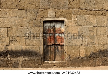 Rusty fort walls with an old rustic door locked with a key
