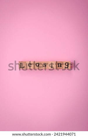 The inscription Leasing made up of wooden cubes on a plain background. Can be used for your design