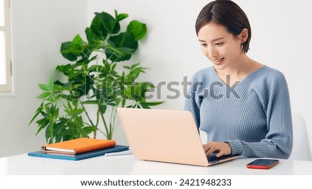 Asian woman working with a laptop PC in private office.