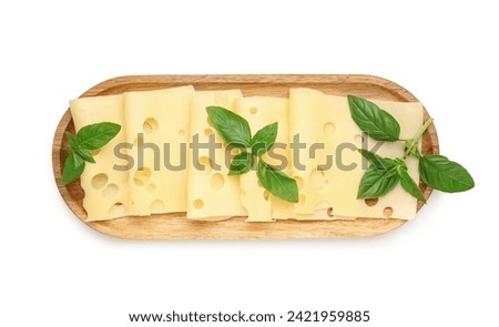 Wooden board with tasty cheese slices and basil leaves on white background Royalty-Free Stock Photo #2421959885