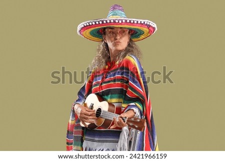 Mature woman in sombrero hat playing guitar on color background. Mexico's Day of the Dead (El Dia de Muertos) celebration Royalty-Free Stock Photo #2421966159