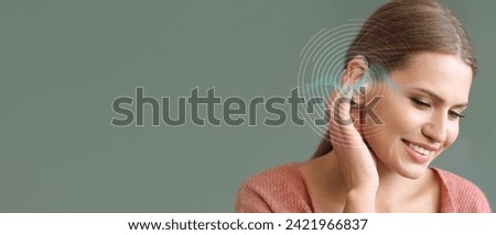 Young woman with hearing aid on green background with space for text Royalty-Free Stock Photo #2421966837
