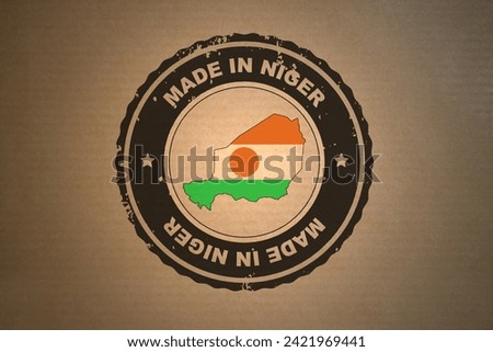 Brown paper with in its middle a retro style stamp Made in Niger include the map and flag of Niger.