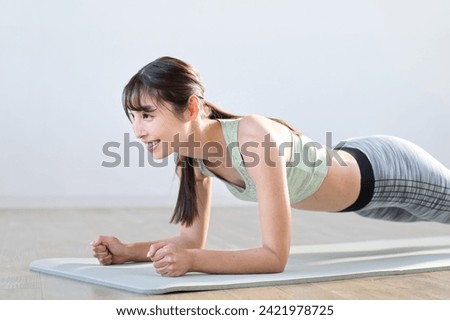 A woman training her core with a plank Royalty-Free Stock Photo #2421978725