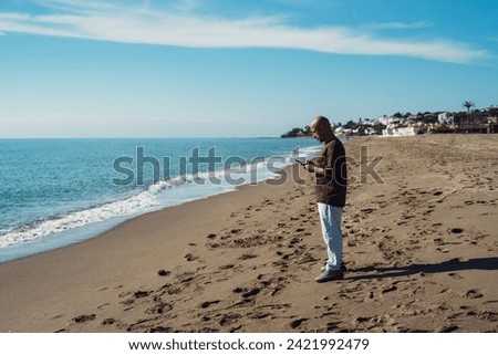 Man taking a picture with his phone. cheerful man takes pictures on his phone. positive emotion and mood. a man travels near the sea.