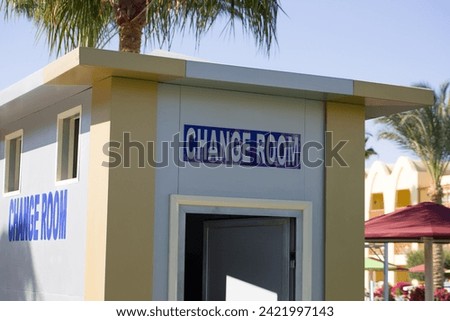 Change room sign on poolside on vacation in sunny day. Entrance to the room for changing a swimsuit while relaxing in the pool