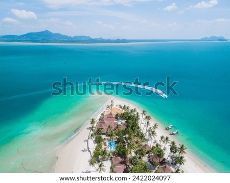 Drone aerial view at Koh Muk a tropical island with palm trees and soft white sand, and a turqouse colored ocean in Koh Mook Trang Thailand, top view at a tropical island