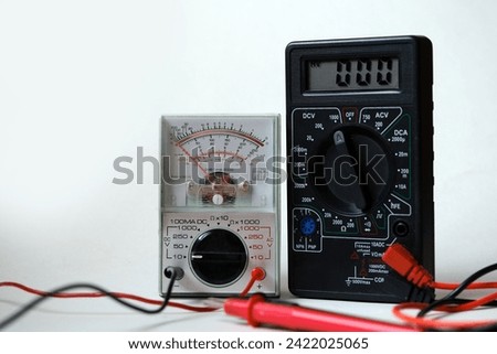 Digital and analog devices in the same frame. Two different types of multimeters. Electrical - electronic test and measurement devices. Royalty-Free Stock Photo #2422025065