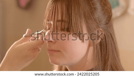 beauty routines and haircare. Personal care close-up video capturing woman's routine grooming session. Scissors delicately trim woman bangs, showcasing artistry and attention to detail in hairstyling. Royalty-Free Stock Photo #2422025205