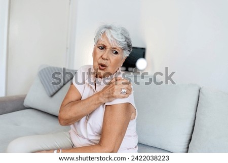 Photo of a aging lady is feeling ache in her body. Senior lady is demonstrating suffering from ache. Elderly woman suffering from pain in shoulder at home. Elderly woman shoulder pain, osteochondrosis