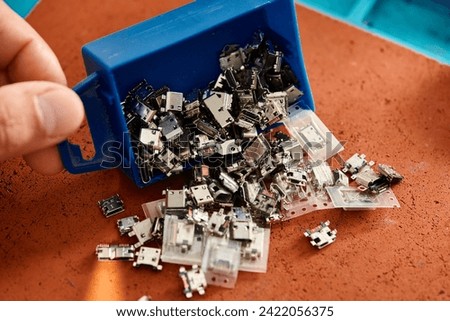cropped view of professional technician with plastic box of different spare parts in repair workshop Royalty-Free Stock Photo #2422056375