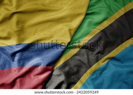 big waving national colorful flag of tanzania and national flag of colombia . macro