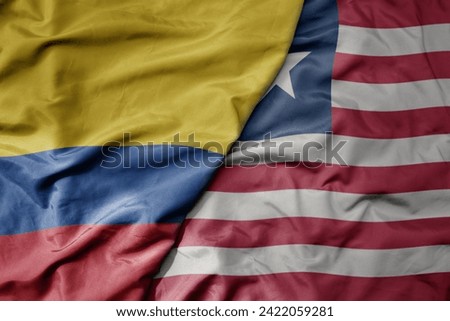 big waving national colorful flag of liberia and national flag of colombia . macro
